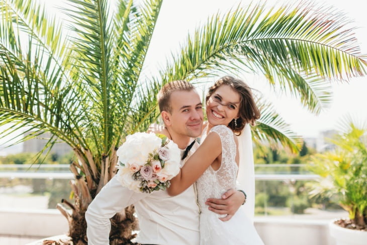 a bride and groom smile together at their wedding