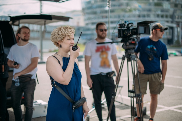 a director speaks into her walkie-talkie while on set