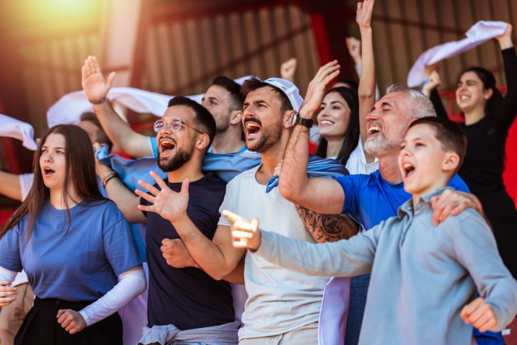 a group of fans excitedly cheer for their favorite team
